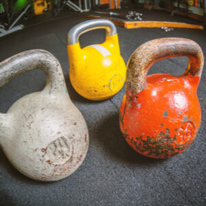 Three kettlebells on a floor in gym