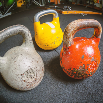 Three kettlebells on a floor in gym